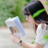 selective focus photo of woman reading book